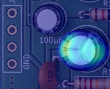 An illustration of defect detection in PCB component placement showing the anomalous area highlighted in bright colour.