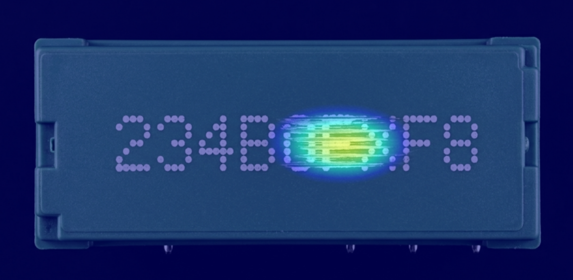 An illustration of defect detection in component marking showing the anomalous area highlighted in bright color.